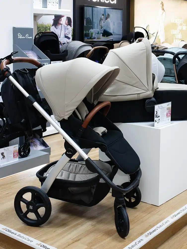 Display of various baby strollers arranged in rows, showcasing different colors and designs in a store.