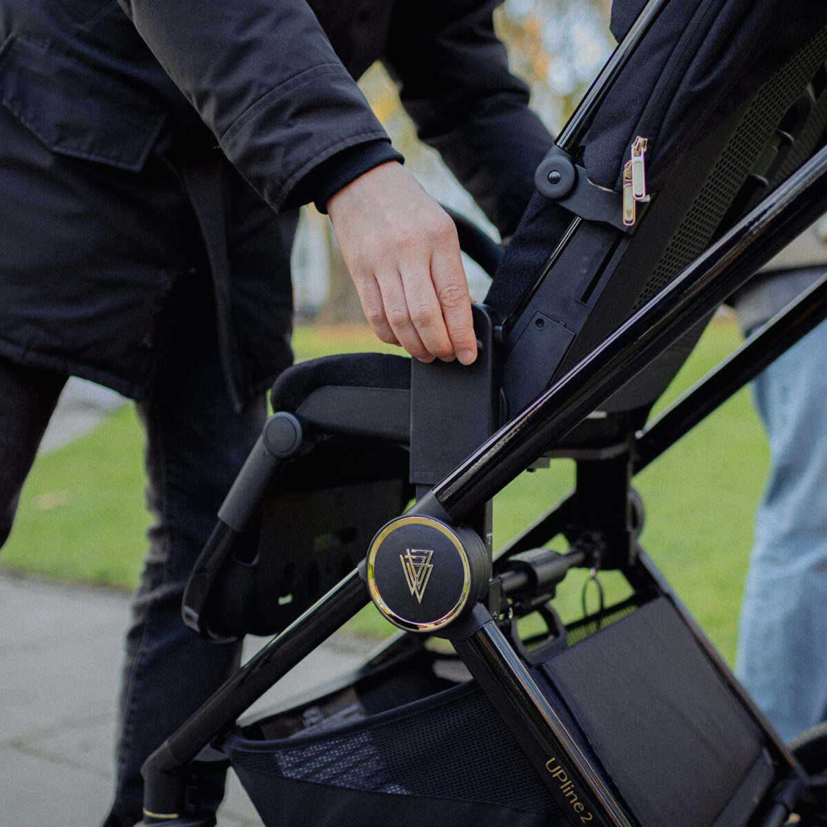 Close up view of parents installig the venicci upline 2 seat unit on the pushchair frame