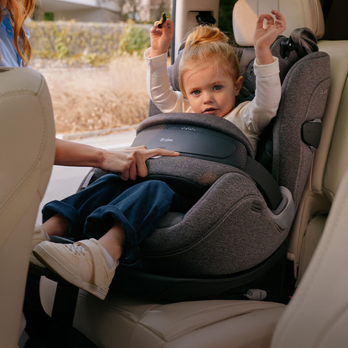 Parent getting an extended rear facing car seat ready for a car journey.